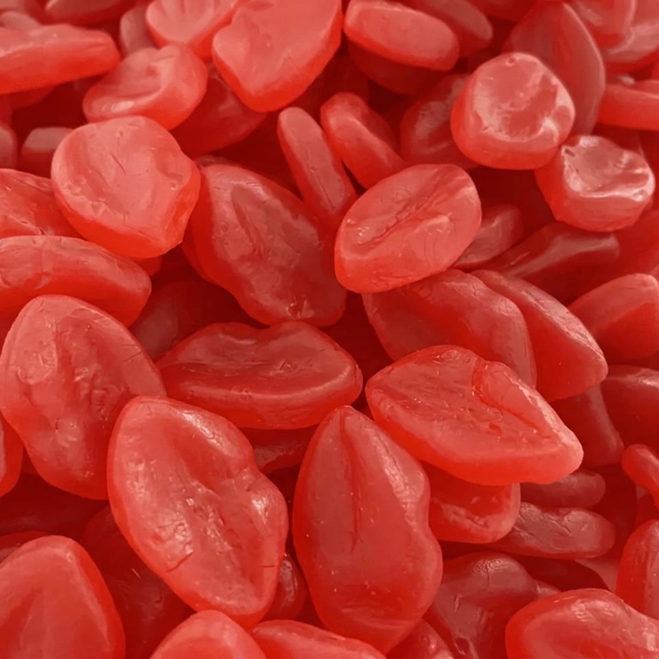 Close-up of translucent red candied fruit pieces piled together.